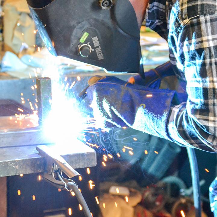welder using torch wearing heat resistant gloves