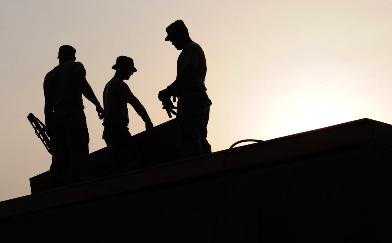 Workers on Roof Working with their Hands